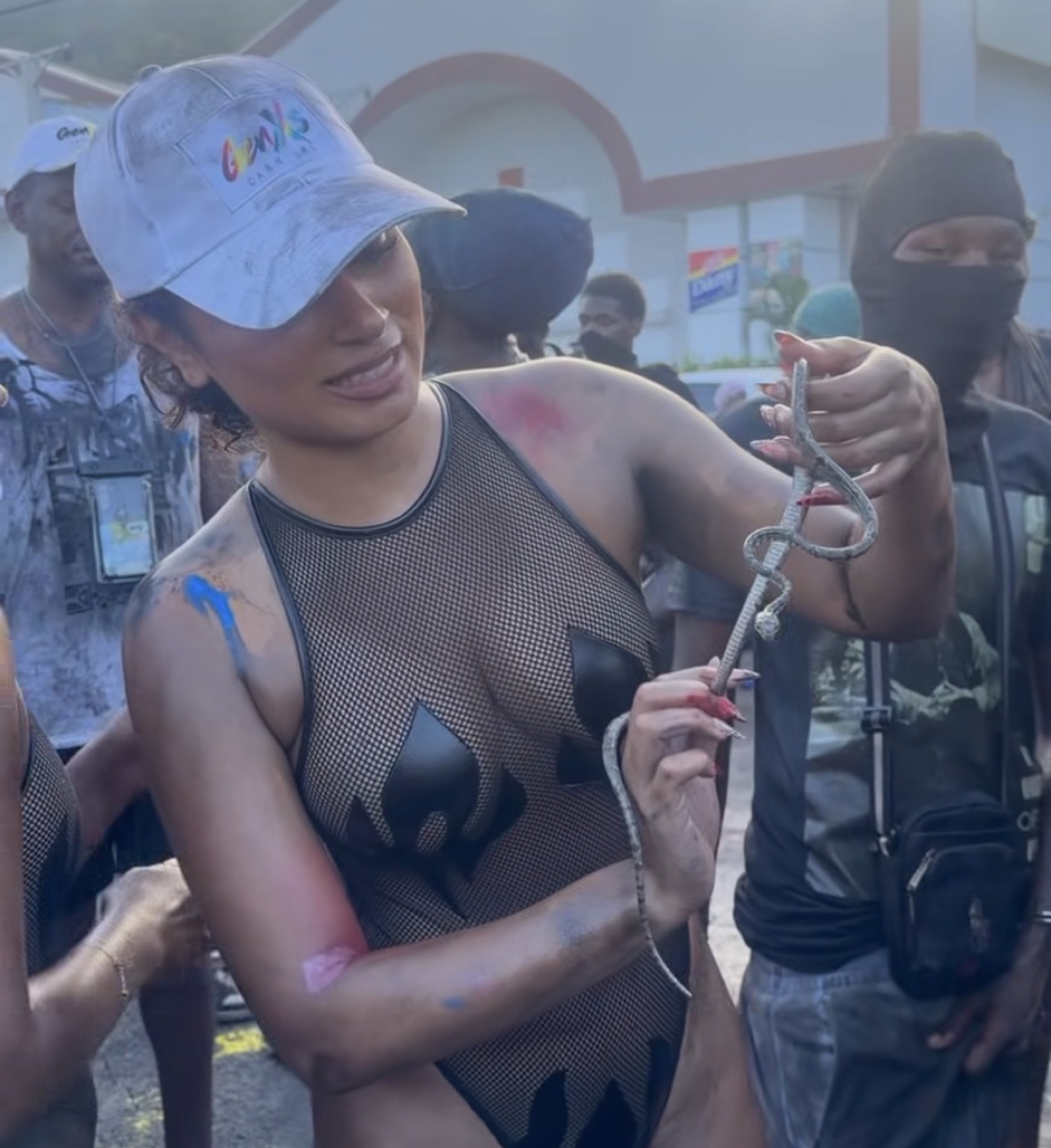 Dania Duntin holding a live snake while playing Jab at Spicemas J'ouvert in Grenada