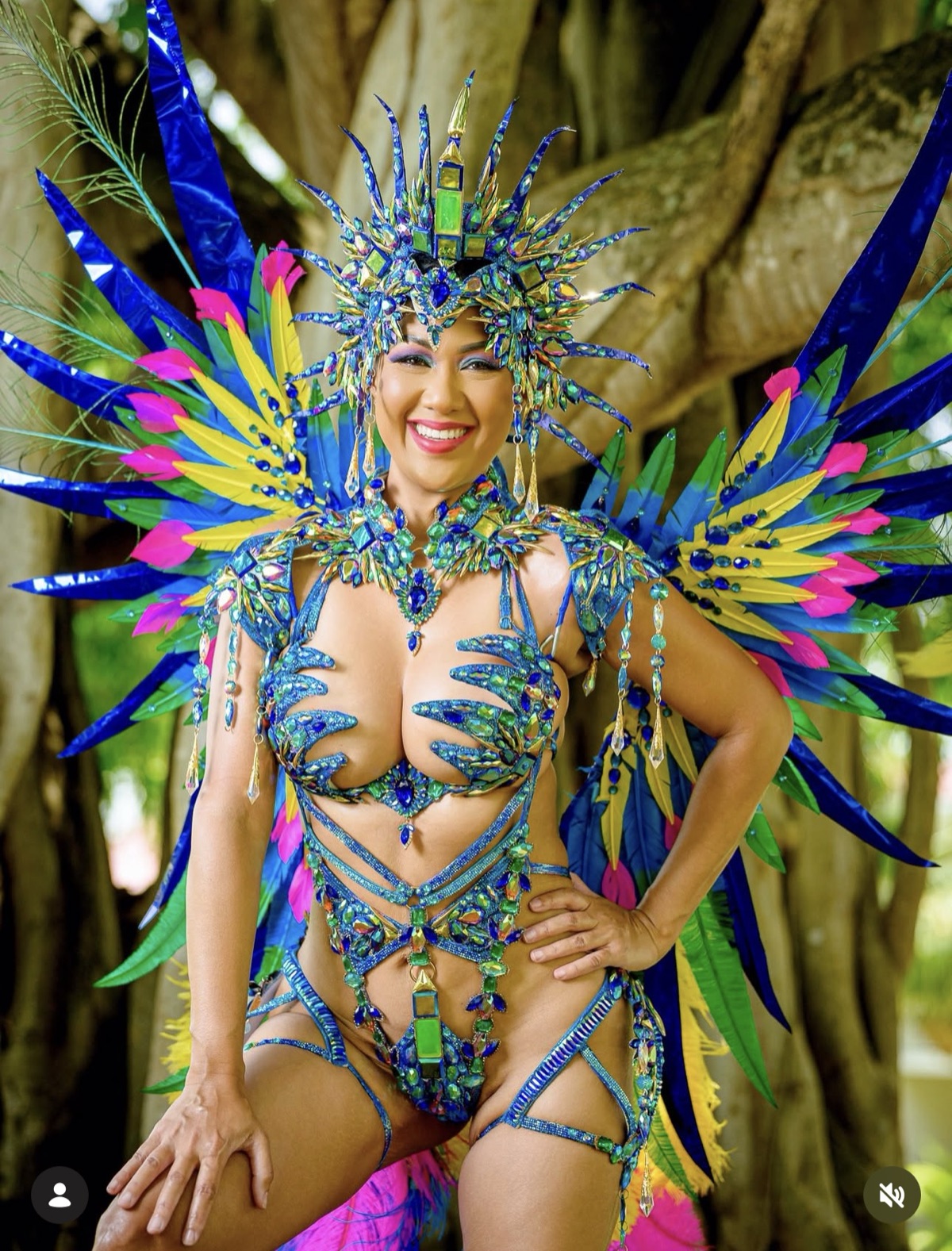 Melissa Liu in a blue, green and yellow feathered Spicemas costume in Grenada with Carnival Glam Hub makeup and photoshoot
